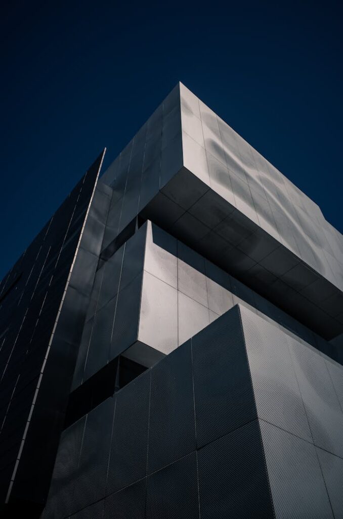 Low angle view of a modern building's exterior with clean lines and a dramatic perspective.